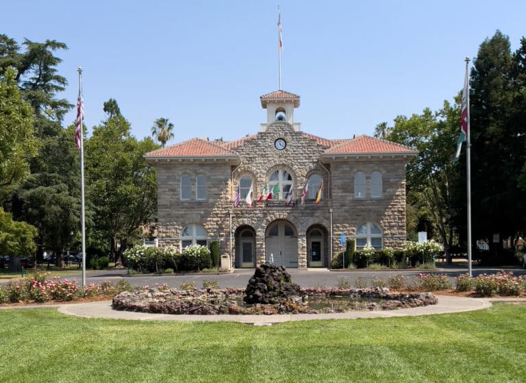 Beautiful stone architecture and lush garden with flags in Sonoma, showcasing local government and community pride.