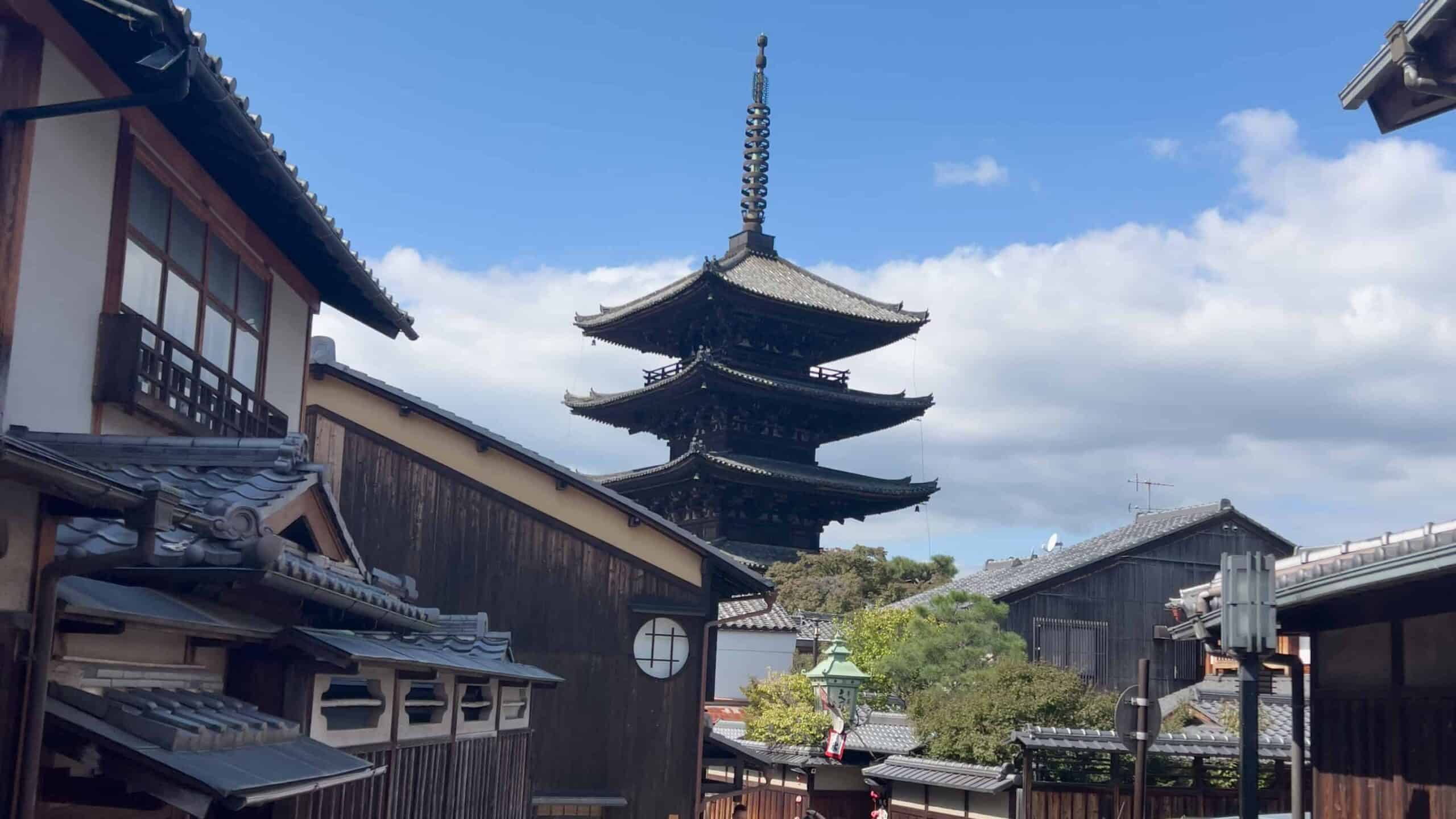 Beautiful ancient pagoda surrounded by traditional Japanese architecture in a scenic town setting.